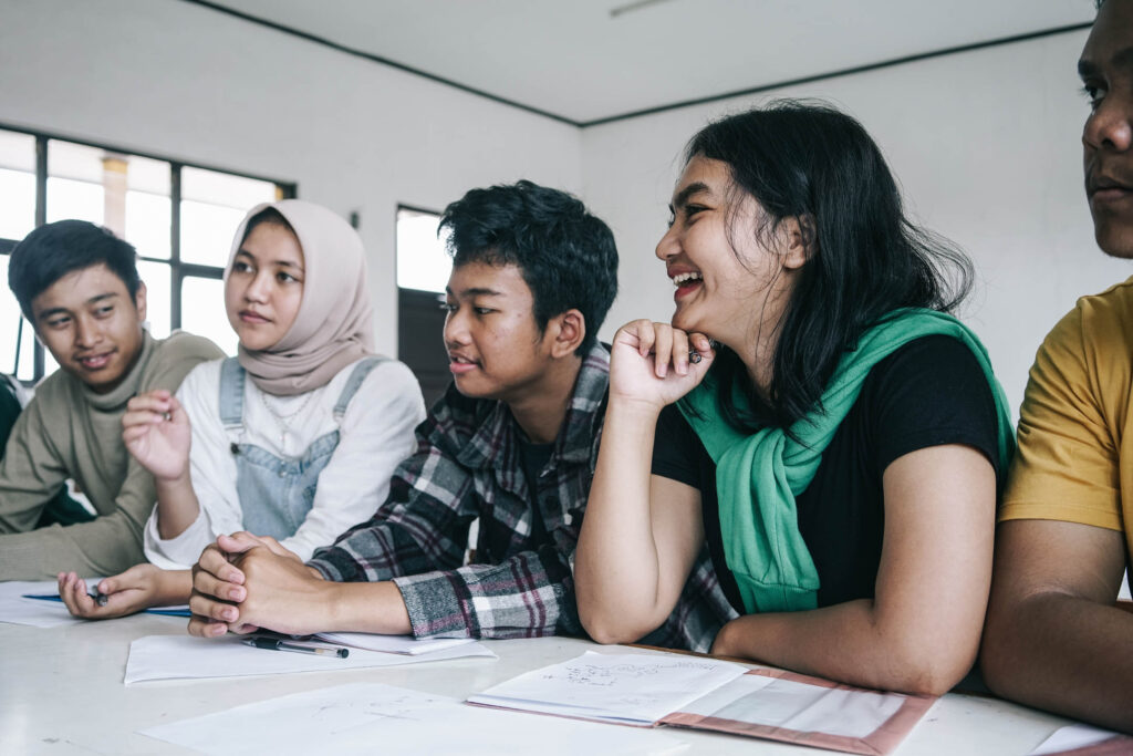group young asian diverse friends sitting together having joyful conversation classroom